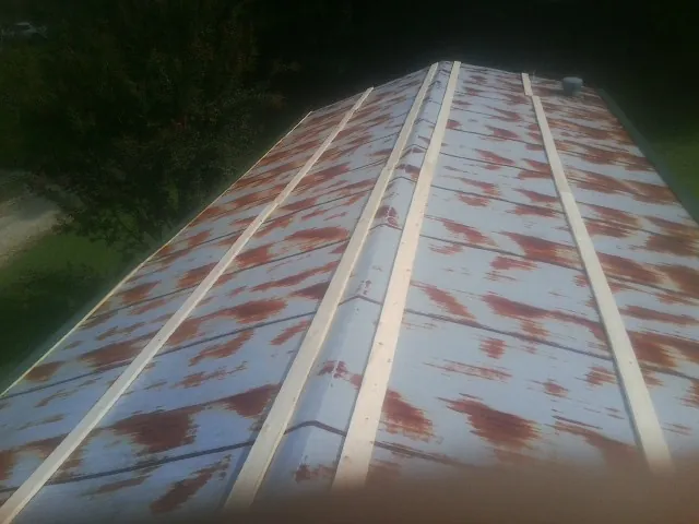 Rusted metal roof panels with new wood purlins before replacement — Storm Damage Roof Repair in Davison by Roofing Brothers