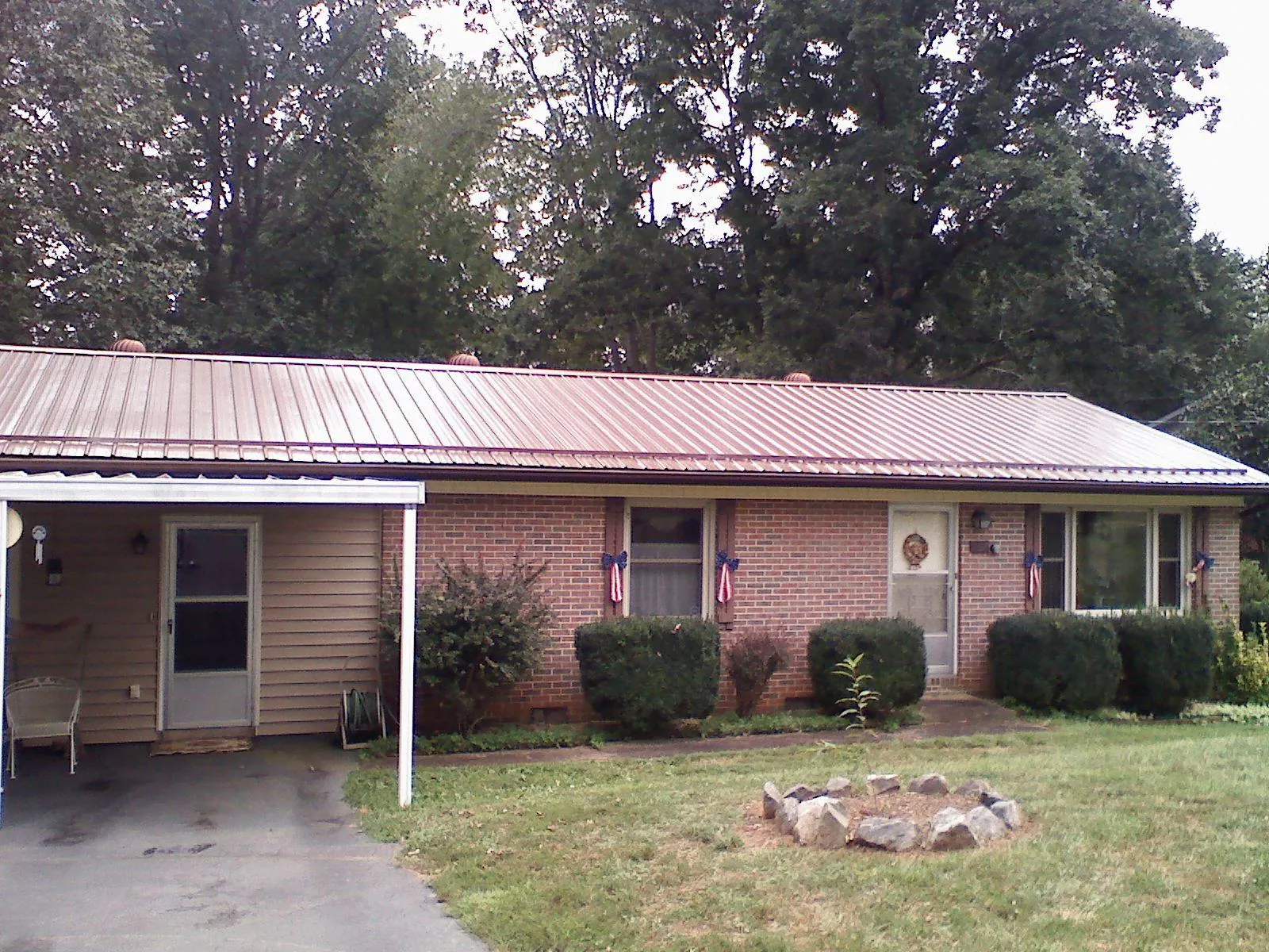 Bronze metal roof and carport on a brick ranch home — Roof Repair work by our crew in Davison